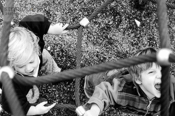 Kinder spielen an Seilen  schreien  einer schaut in die Kamera  Blick über Kopf