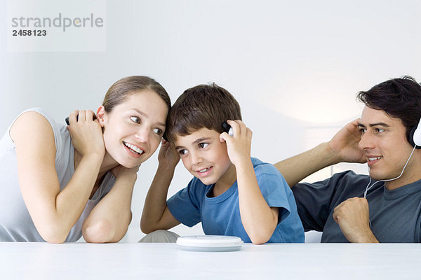 Familie hört gemeinsam CD-Player  Mutter und Sohn teilen sich Kopfhörer