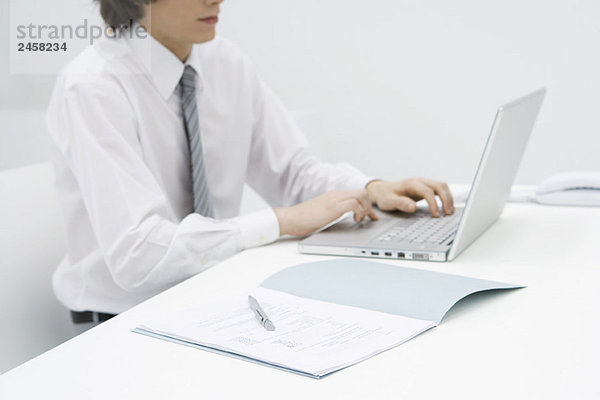 Mann am Schreibtisch sitzend mit Laptop  Ausschnittansicht