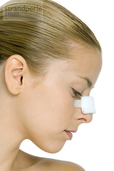 Junge Frau mit bandagierter Nase  Profil