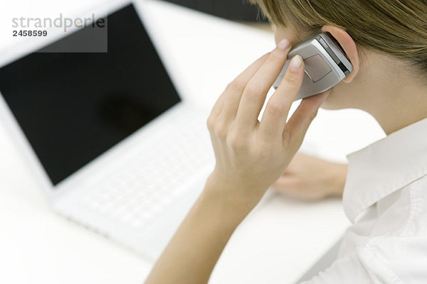 Frau mit Handy und Laptop  Ausschnittansicht