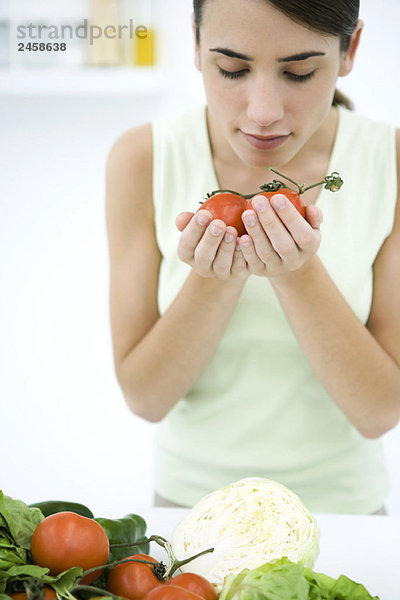 Frau riecht reife Strauchtomaten  Nahaufnahme