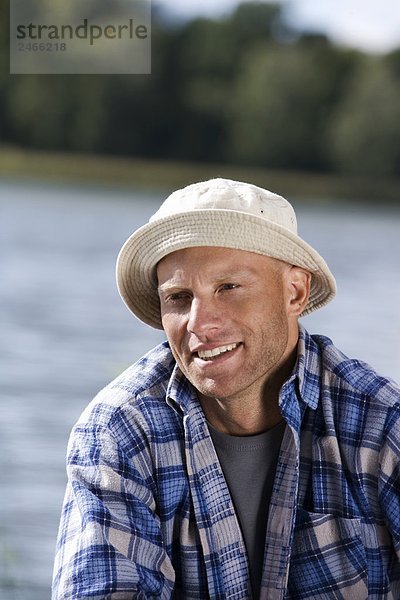 Portrait von einem lächelnd mann am Wasser Schweden.