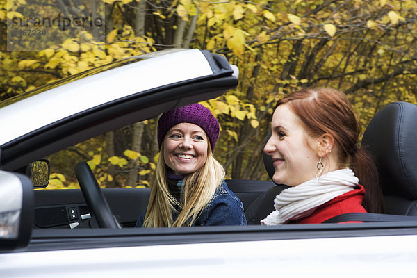 Zwei junge Frauen fahren ein Cabriolet ein Herbsttag Schweden.