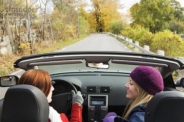 Zwei junge Frauen fahren ein Cabriolet ein Herbsttag Schweden.