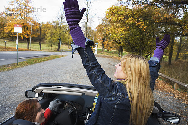 Zwei junge Frauen fahren ein Cabriolet ein Herbsttag Schweden.