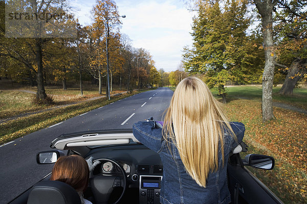 Zwei junge Frauen fahren ein Cabriolet ein Herbsttag Schweden.