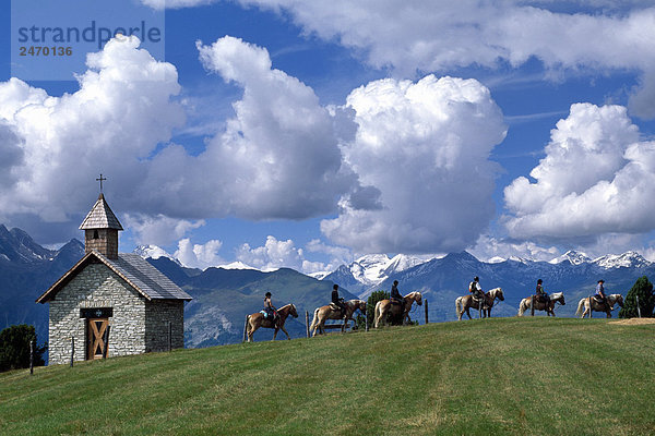 Touristen Reiten auf Pferden mit Gebirge im Hintergrund  hohen Tauern Alpen  Mölltaler  Kärnten  Österreich