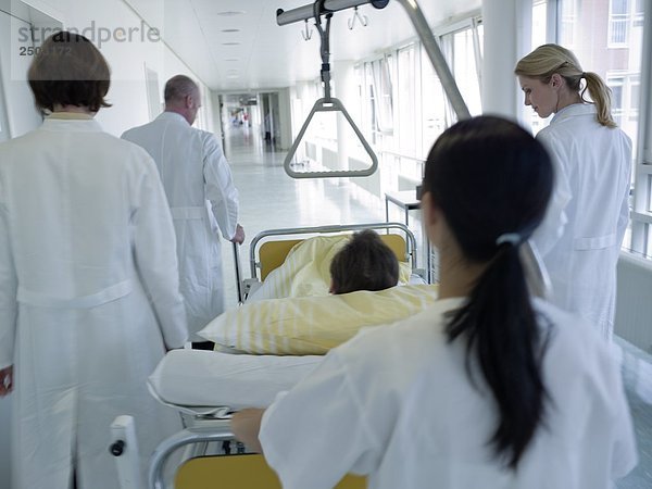 Female Nurse Druck der Patient auf gurney