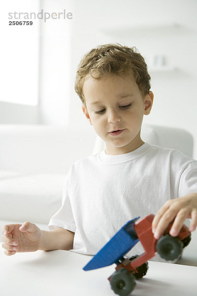 Kleiner Junge spielt mit Spielzeugkipper