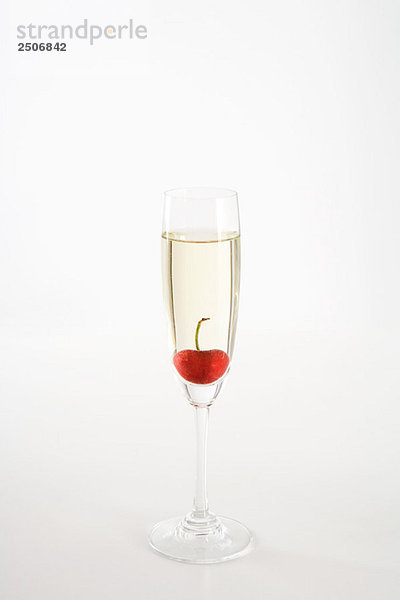 Kirsche schwimmend im Glas Champagner