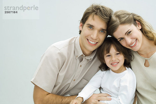 Junge Eltern mit kleinem Jungen  lächelnd vor der Kamera  Porträt