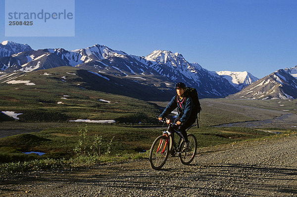 Frau Fahrradfahren auf Denali National Park Road Inland Alaska Frühling