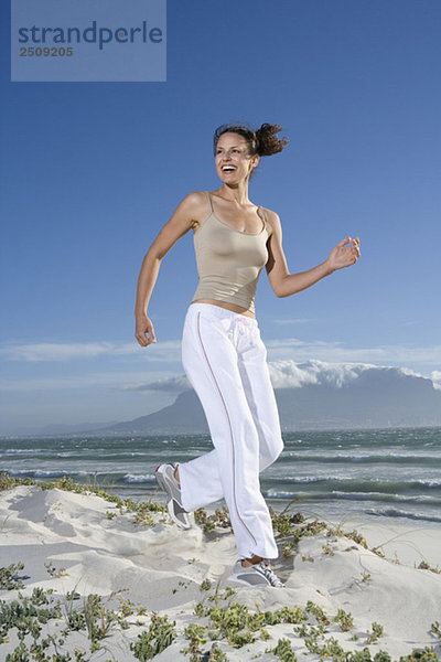 Südafrika  Kapstadt  Junge Frau beim Joggen am Strand