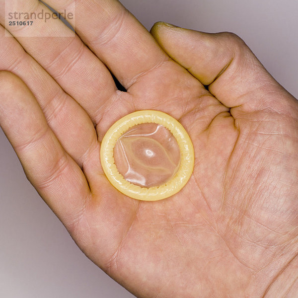 Kondom auf Männerhand  erhöhte Ansicht  Nahaufnahme