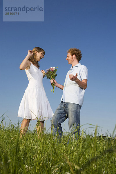 Junges Paar  Mann mit Blumenstrauß
