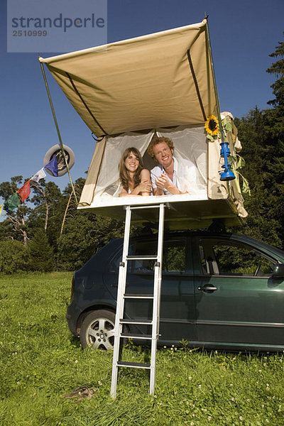 Germany  Bavaria  Young couple laying in tent