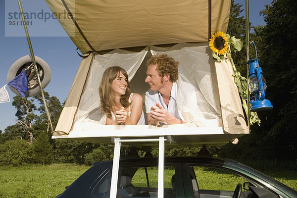 Germany  Bavaria  Young couple laying in tent