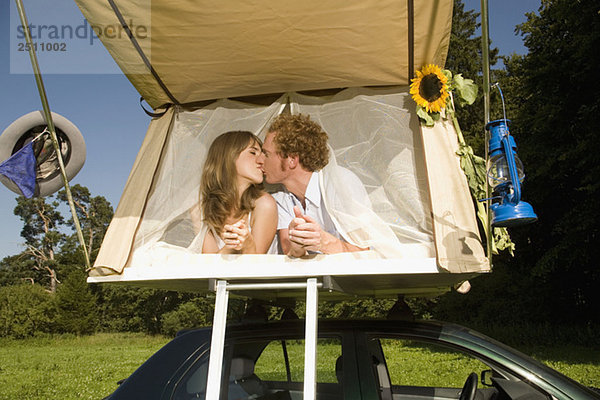 Germany  Bavaria  Young couple laying in tent