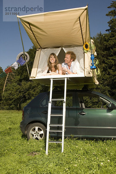 Germany  Bavaria  Young couple laying in tent