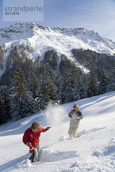 Switzerland  Graubuenden  Savognin  Children (8-9) snowball fight
