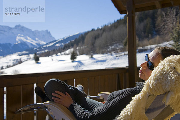Switzerland  Graubuenden  Savognin  woman relaxing on sun terrace