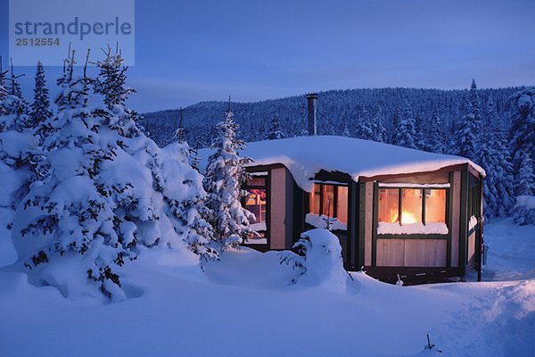 View of La Mesange shelter and snow-covered trees at twilight  Quebec  Canada
