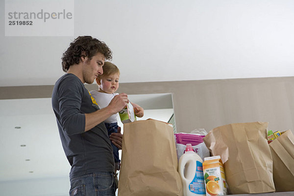 Vater und Baby mit Einkaufstaschen