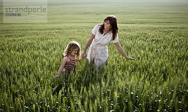 Frau und Kind beim Wandern im Weizenfeld