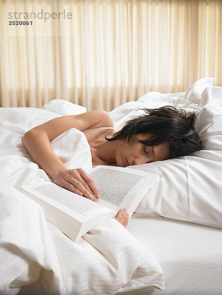 Frau schläft mit offenem Buch