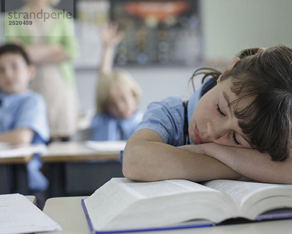 Schulmädchen schläft am Schreibtisch