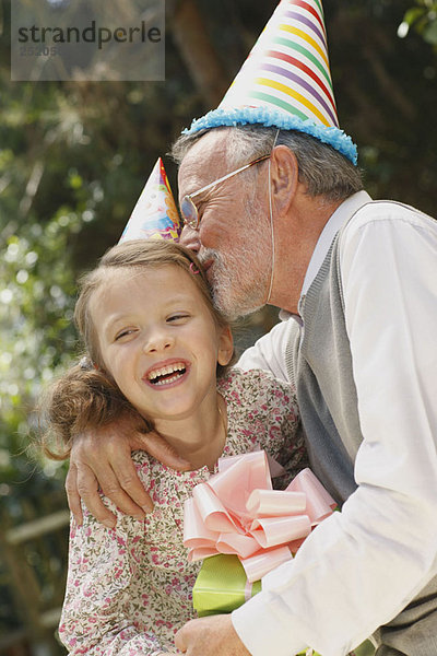 Großvater küsst Enkelkind auf der Party