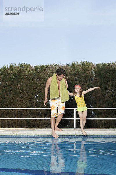 Vater und Mädchen beim Zehentauchen im Pool