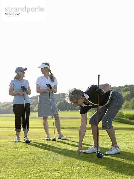 Drei Golferinnen am Abschlag