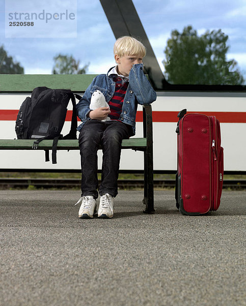 Junge wartet am Bahnhof