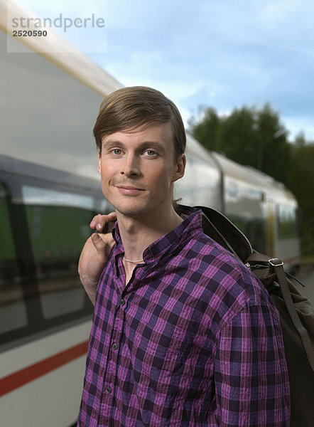 Junger Mann auf dem Bahnhof