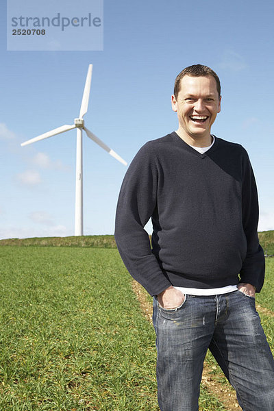 Mann lächelt auf einem Windpark