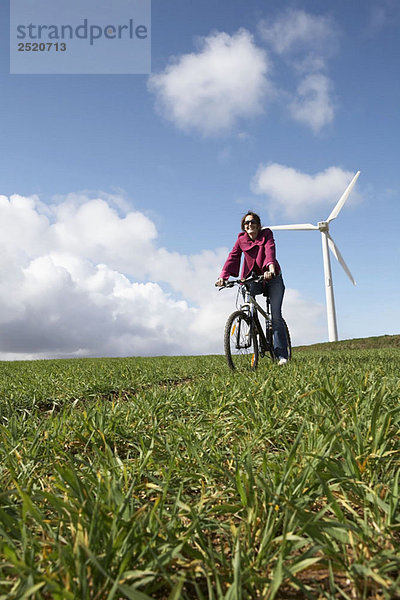 Frau beim Radfahren auf einem Windpark