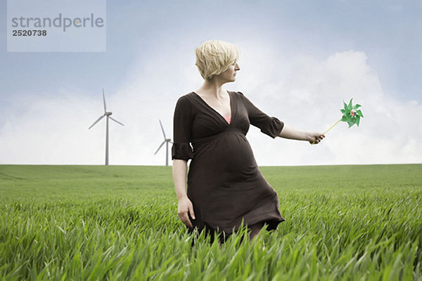 Schwangere Frau spielt mit Windmühle