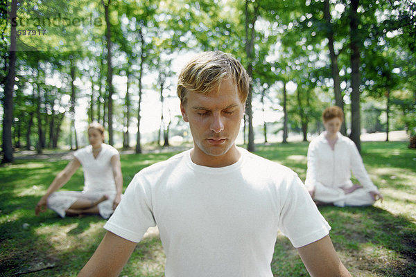 Menschen  die meditieren in Park