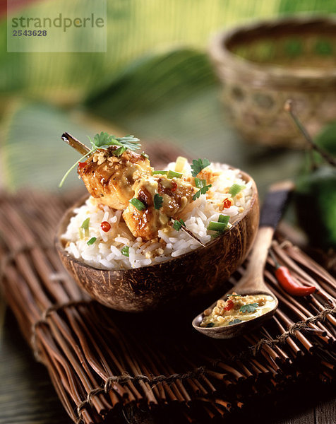 Huhn Spieß mit Kokosmilch Reis in einem Kokosnußschale