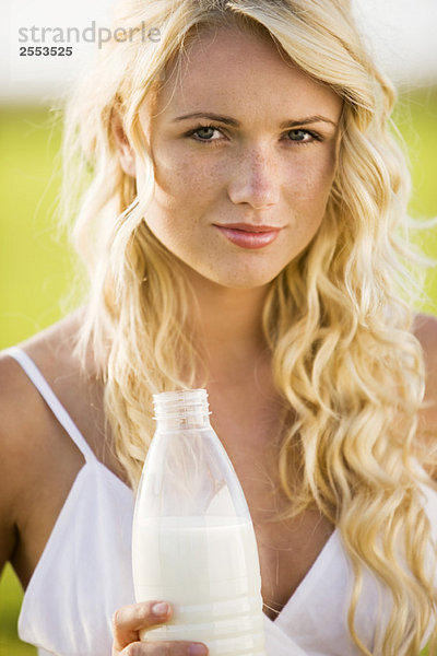 Junge Frau mit einer Milchflasche