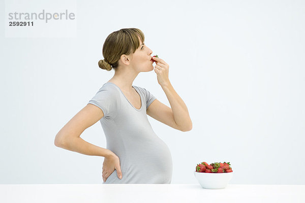 Schwangere essen Erdbeeren  Seitenansicht