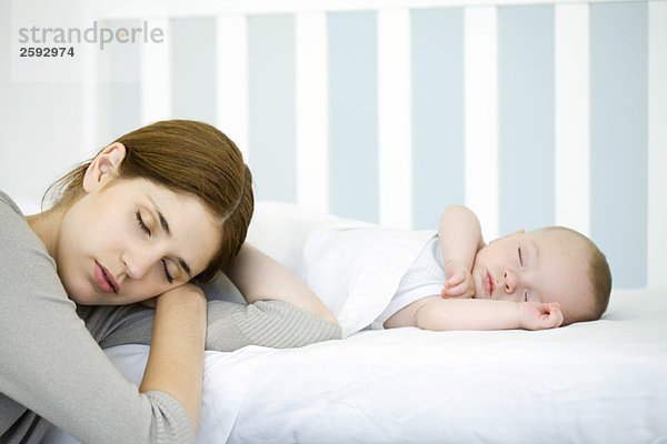Mutter ruhender Kopf neben schlafendem Kind  Augen geschlossen