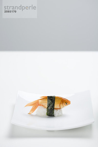 Goldfisch zubereitet als Nigiri-Sushi auf kleiner Sushi-Platte