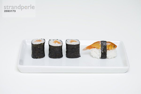 Maki Sushi und Goldfisch-Nigiri auf dem Teller