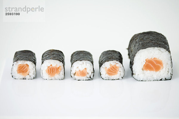 Fünf Stücke Maki-Sushi in Reihe angeordnet  Endstück größer als andere