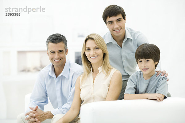 Familie sitzt zusammen auf der Couch  lächelnd  Portrait