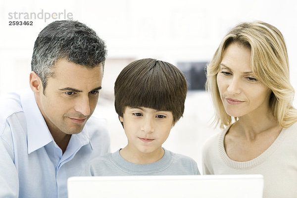 Familie beim gemeinsamen Betrachten eines Laptops  Nahaufnahme