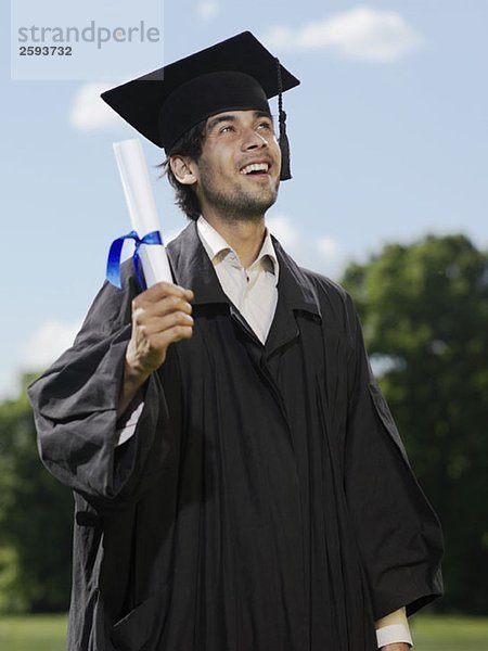 Ein männlicher Absolvent mit einem Diplom